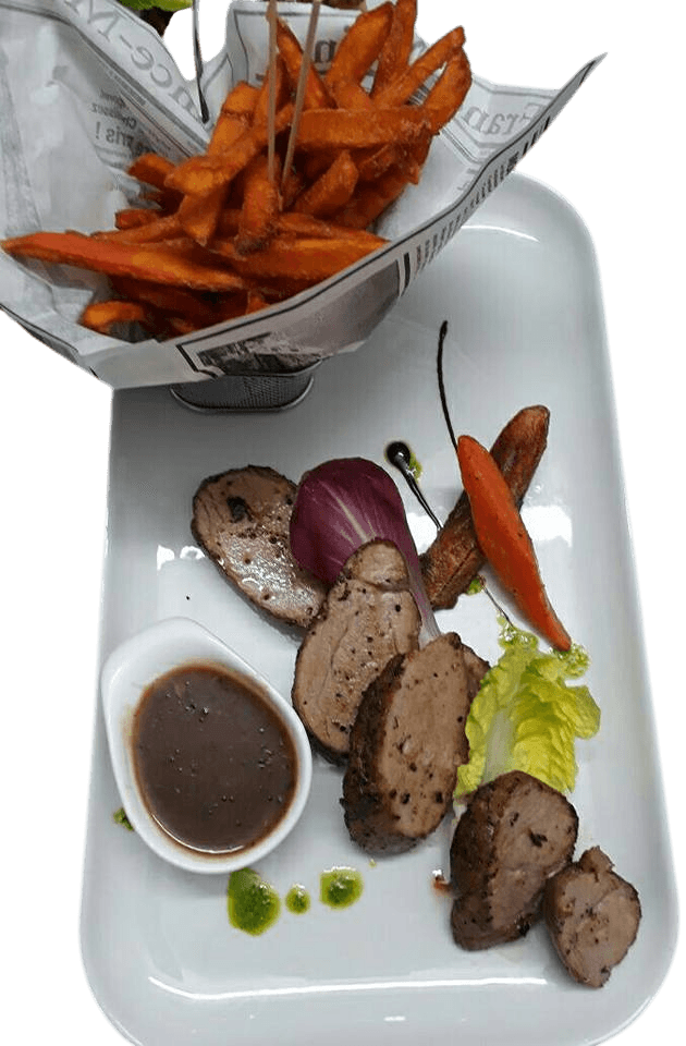 Plat de viande en tranches, servi avec une sauce brune et de frites de patates douces Martinique